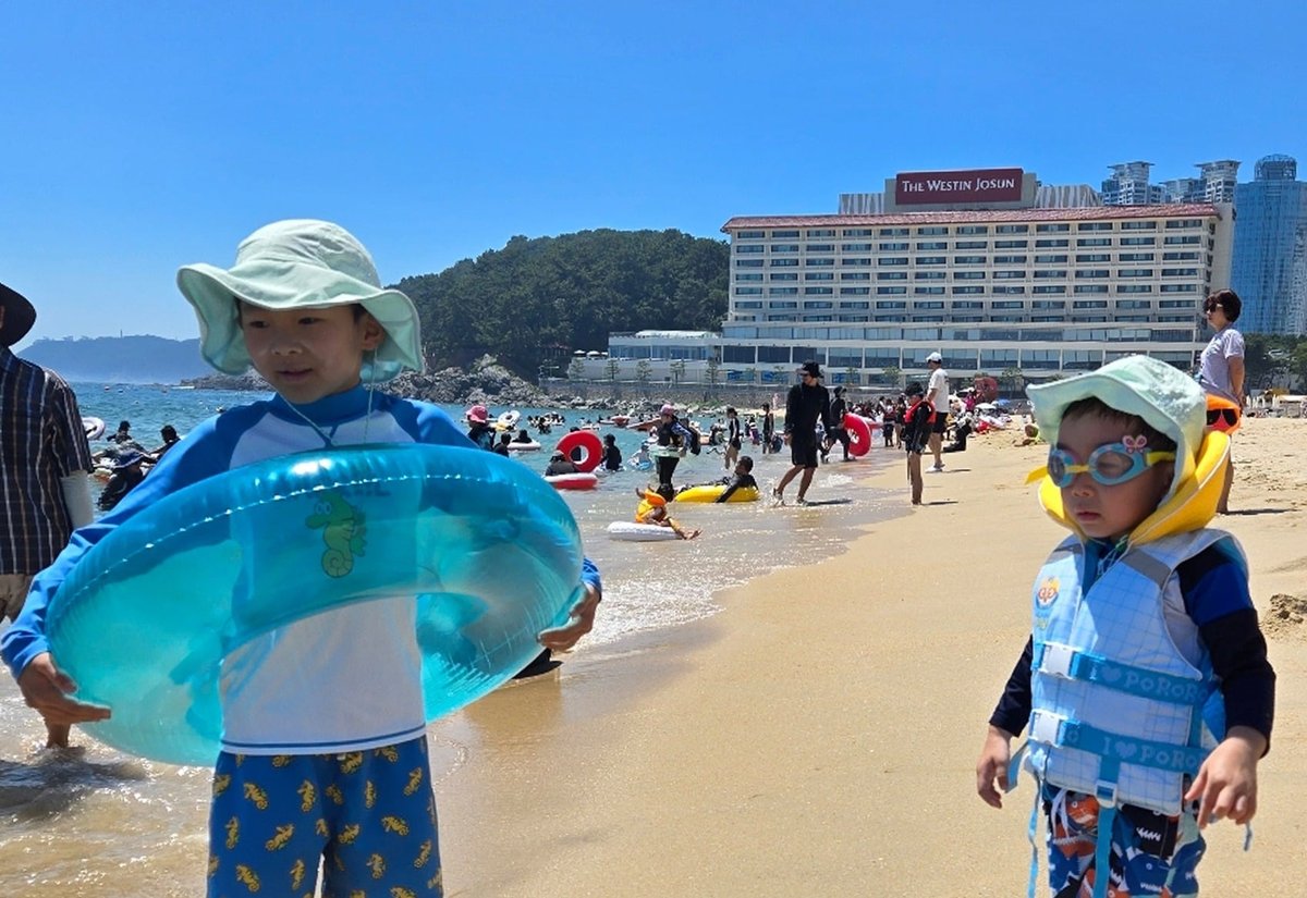 해변에서 튜브를 든 두 아이