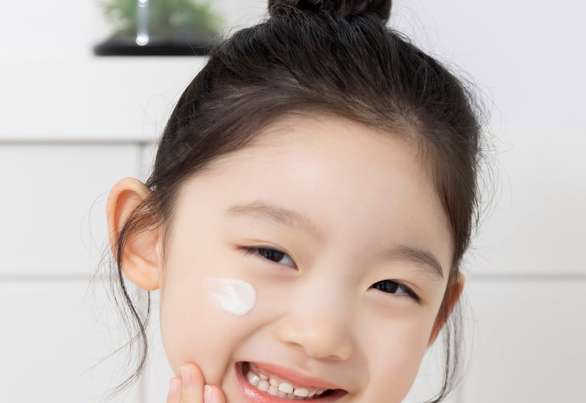 볼에 크림을 묻히고 웃는 여자아이