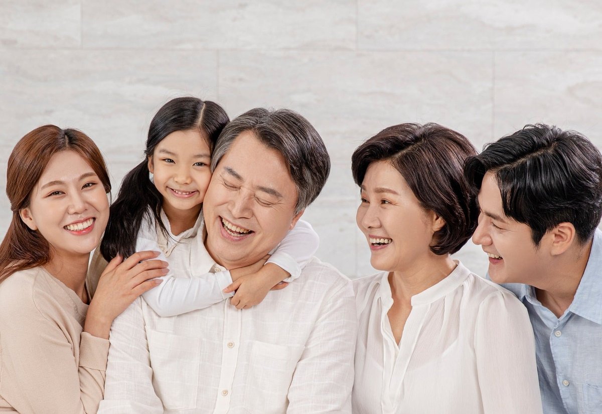 소파에 함께 앉아 웃고 있는 삼대 가족
