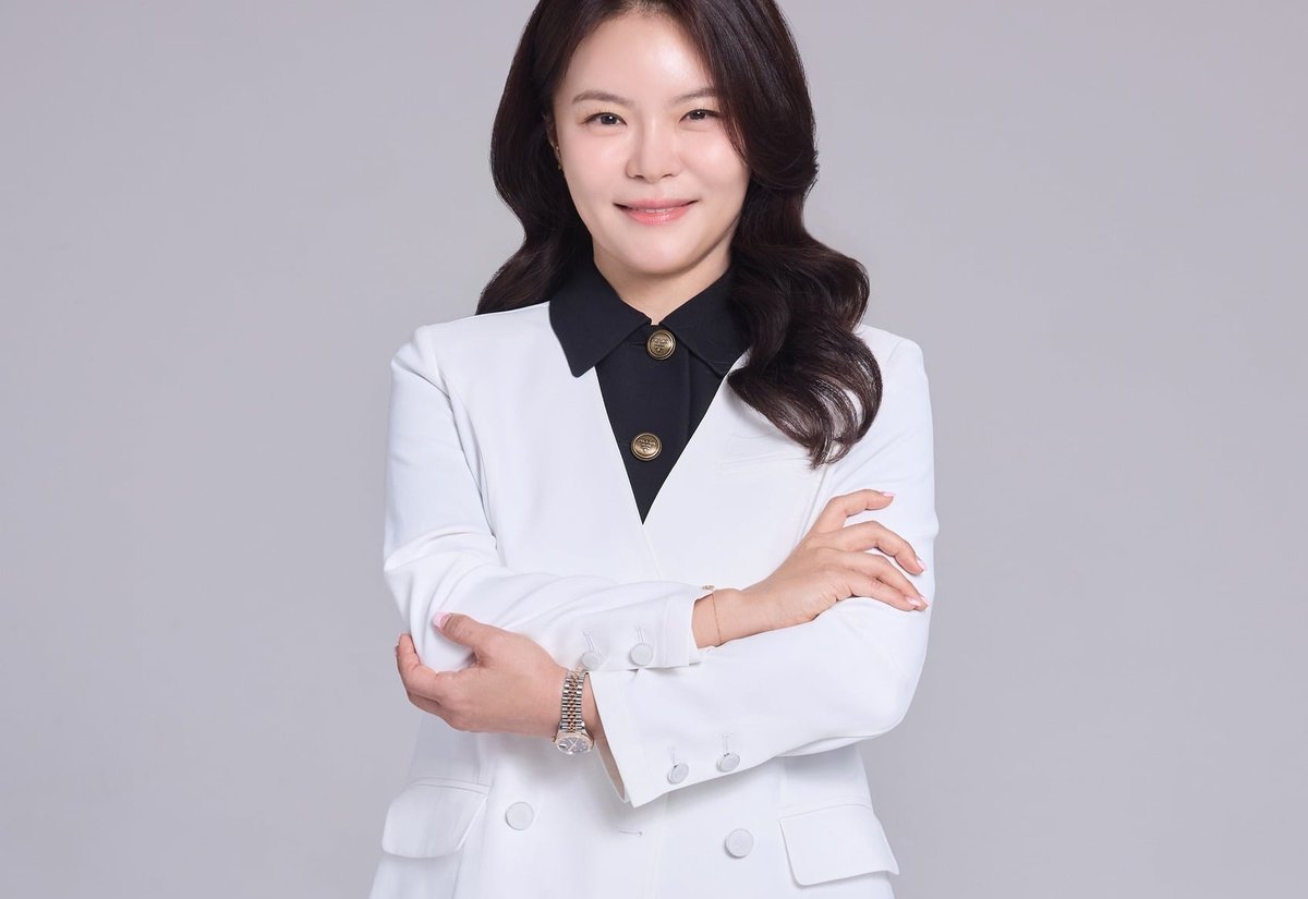 흰 재킷을 입고 팔짱을 낀 약사