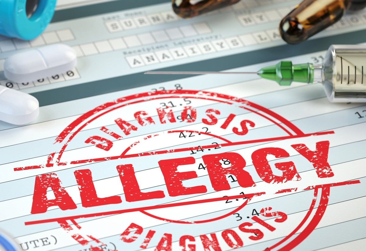 혈액 검사지 위에 찍힌 ‘ALLERGY DIAGNOSIS’ 붉은 도장과 주사기, 앰풀, 알약