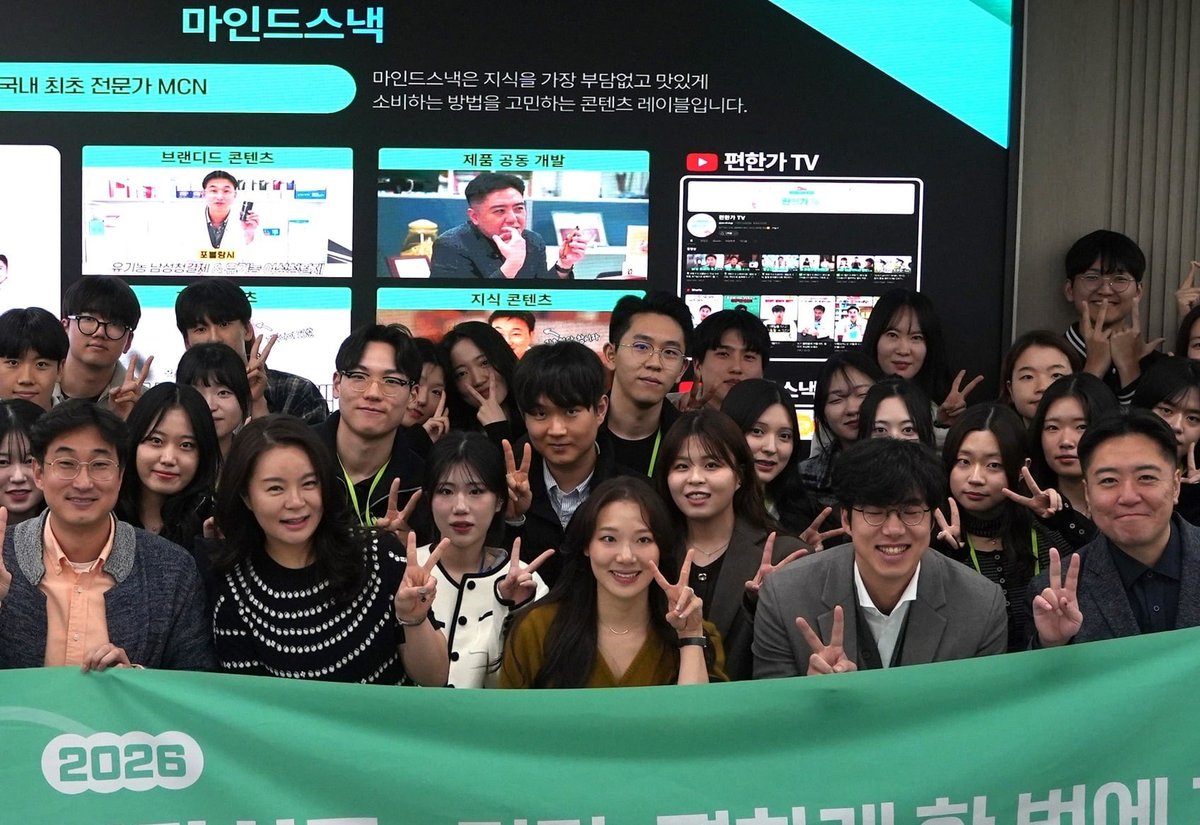 마인드스낵 소개 화면 앞에서 2026 현수막을 들고 브이 포즈를 한 행사 참가자들의 단체 사진